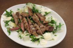 Tagliata di carne con rucola e scaglie di formaggio